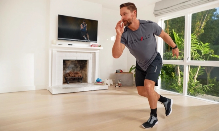 Man doing Studio SWEAT workout in his living room.