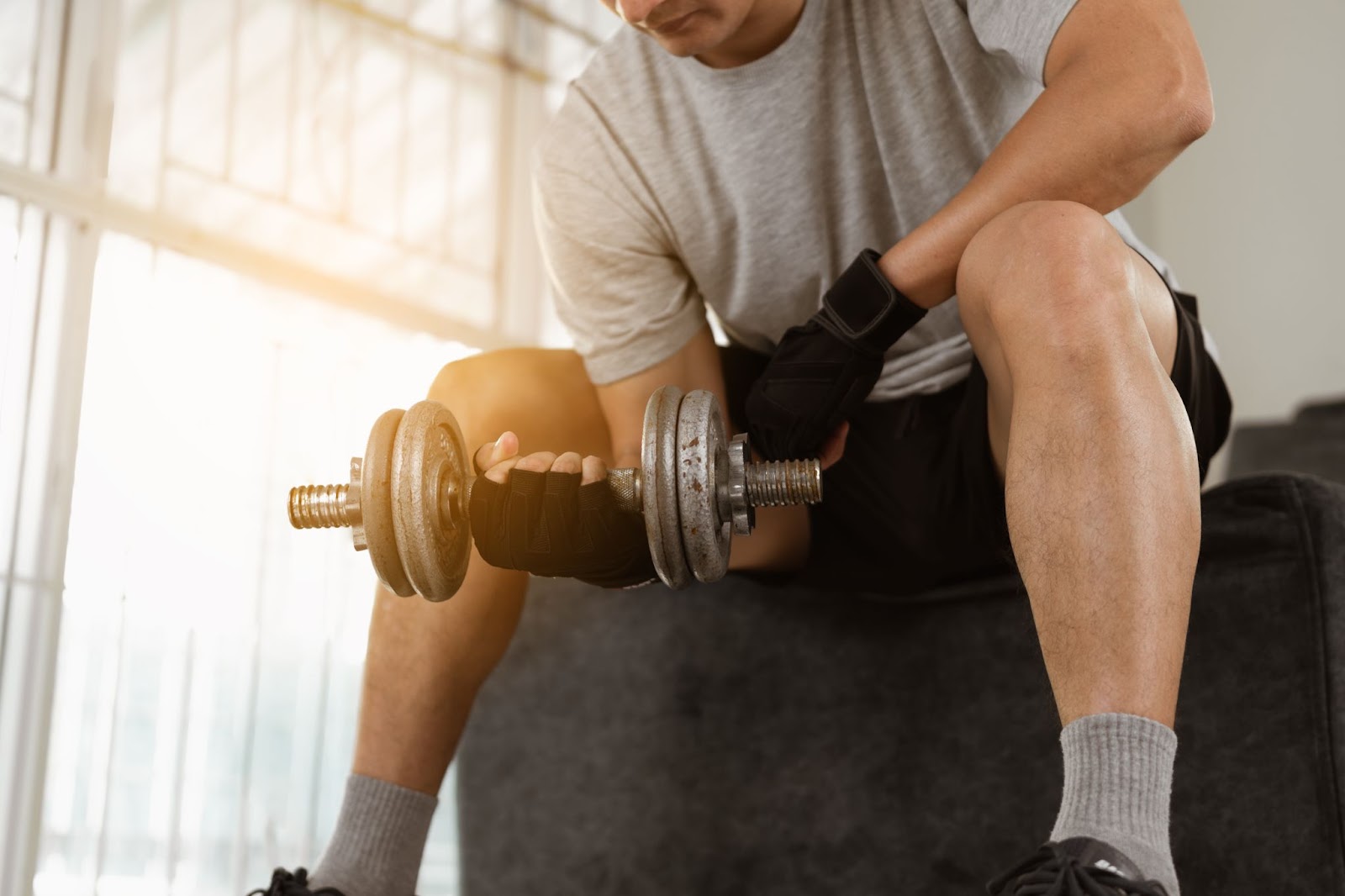 Image of fit man wearing workout gloves doing a bicep curl