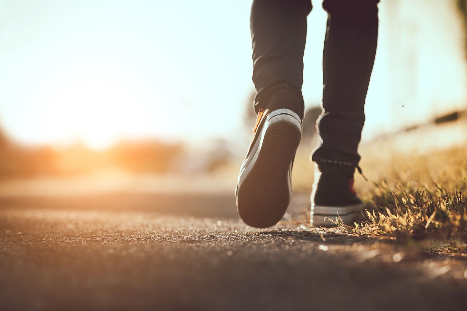 Close up shot of a person wearing sneakers and going for a walk outside